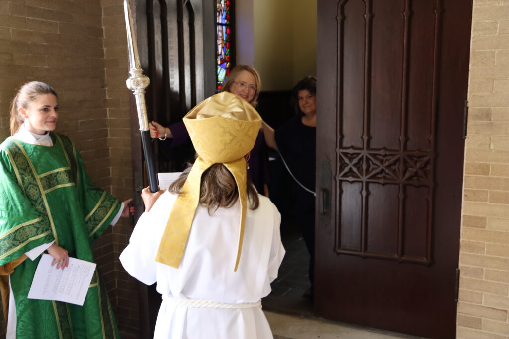 Bishop Wells, led by the Rev. Sarah Stripp, deacon, is greeted at the door of St. Andrew’s Cathedral by Senior Warden Margaret McLarty and Junior Warden Michelle Lewis